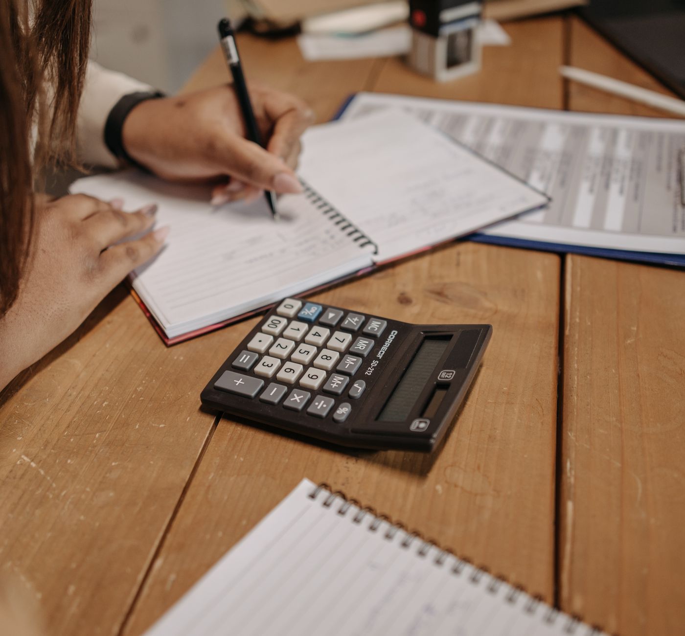 Bookkeeping — working through the books at a desk with a calculator